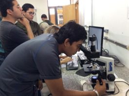 Estudante da Bolívia utiliza microscópio durante a visita – Foto: Ana Maio